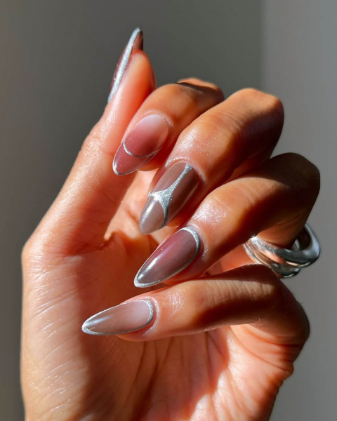 Hand with fingers curled in showing a pinky ombre base with silver line details.